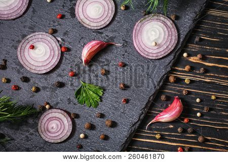 Pepper Peas Scattered Randomly, Onion, Garlic And Dill On A Dark Background