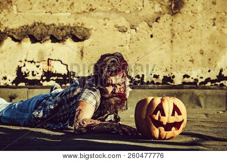 Bearded Zombie Man With Beard Creepy Vampire Or Bloody War Soldier With Wounds And Red Blood Lies On