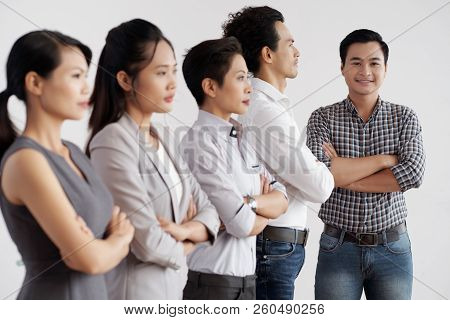 Confident Smiling Businessman And Group Of Hiis Employees