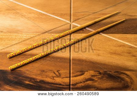 Natural Bamboo Chopsticks On Wooden Table Background.