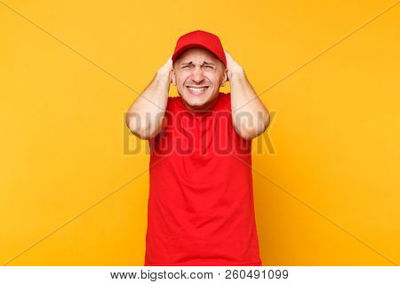 Delivery Man In Red Uniform Isolated On Yellow Orange Background. Professional Perturbed Shocked Mal