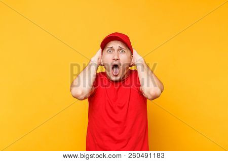 Delivery Man In Red Uniform Isolated On Yellow Orange Background. Professional Perturbed Shocked Mal
