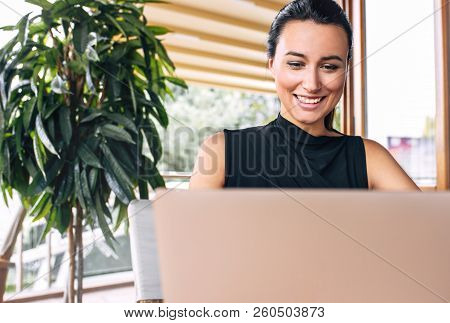 Candid Closeup Image Of A Happy Business Woman Smiling And Working With Laptop In A Cafe. Portrait O
