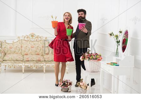 New Life Concept. Happy Woman And Man Smile With Flowers In Pots, New Life. New Life Blossom. Spring