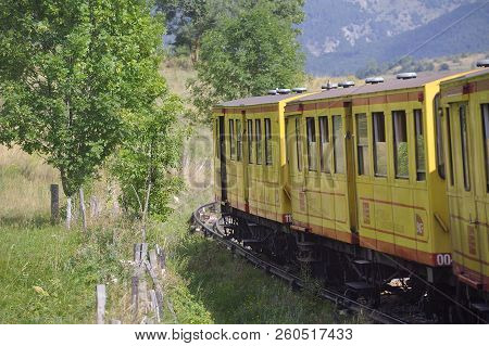 Latour De Carol - September 4, 2018: The Small Yellow Train Of The Pyrenees Crossing A Beautiful Mou