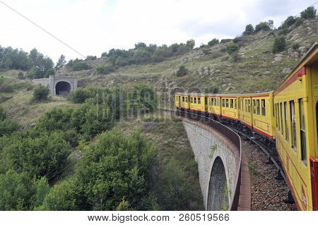 Latour De Carol - September 4, 2018: The Small Yellow Train Of The Pyrenees Crossing A Beautiful Mou