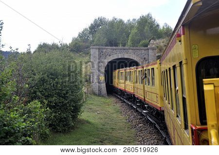 Latour De Carol - September 4, 2018: The Small Yellow Train Of The Pyrenees Crossing A Beautiful Mou