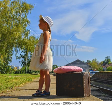 Adorable Little Girl On A Railway Station, Waiting For The Train With Vintage Suitcase. Traveling, H