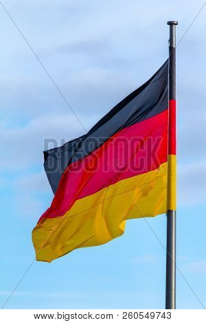Federal Republic Of Germany, German National Flag Waving On The Blue Sky Background