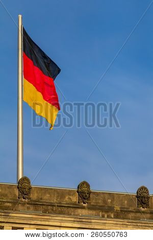 Federal Republic Of Germany, German National Flag At The Parliament Building Waving On The Blue Sky 
