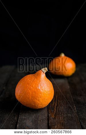 Small Orange Pumpkins On The Dark Wooden Table, Autumn Concept, Harrvest Time. Copy Space.