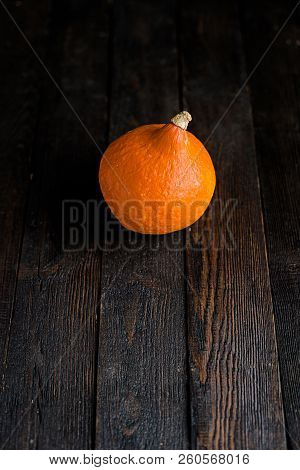 Small Orange Pumpkins On The Dark Wooden Table, Autumn Concept, Harrvest Time. Copy Space.
