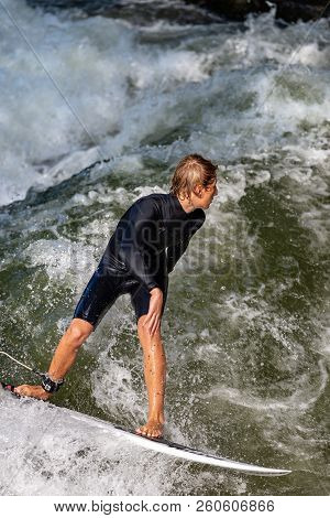 Munich, Germany - Sept 8, 2018: A Man Surfing In The Waves Of The Eisbach River In Downtown Of Munic