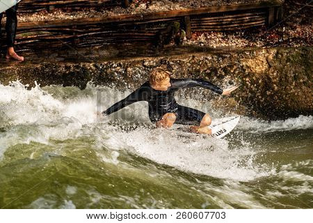 Munich, Germany - Sept 8, 2018: Man Surfing In The Waves Of The Eisbach River In Munich. It Forms A 