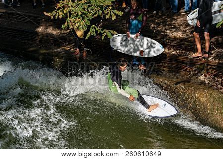 Munich, Germany - Sept 8, 2018: A Man Surfing In The Waves Of The Eisbach River In Downtown Of Munic