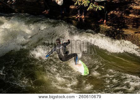 Munich, Germany - Sept 8, 2018: A Man Surfing In The Waves Of The Eisbach River In Downtown Of Munic