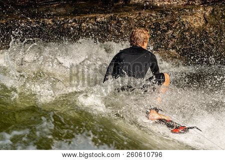 Munich, Germany - Sept 8, 2018: Man Surfing In The Waves Of The Eisbach River In Munich. It Forms A 
