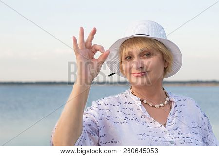 Happy Retired Lady Woman In White Hat Shows Okey Geste