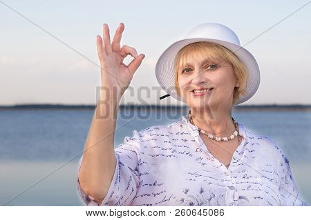 Retired Elderly Lady Woman In White Hat Shows Okey Geste