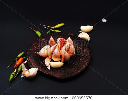 The Abstract Artdesign Background Of Garlic On Wooden Dish And Fresh Chili ,put On Black Background.