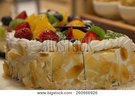 A Cuted Fruit Birthday Cake With Mixedfruit On It