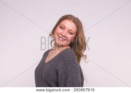 Portrait Of Fashionable Young Blonde Woman With Curly Hair In Grey Cardigan On White Background