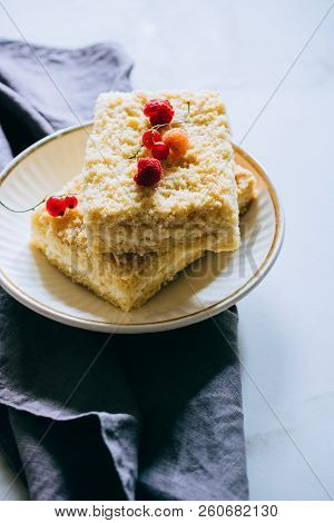 Pieces Of Cottage Cheese Cake With A Crumble Decorated With Raspberries And Red Currants On A White