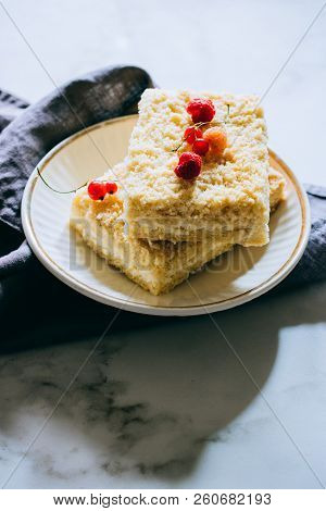 Pieces Of Cottage Cheese Cake With A Crumble Decorated With Raspberries And Red Currants On A White