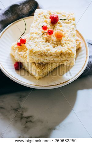 Pieces Of Cottage Cheese Cake With A Crumble Decorated With Raspberries And Red Currants On A White