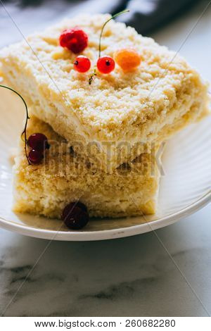 Pieces Of Cottage Cheese Cake With A Crumble Decorated With Raspberries And Red Currants On A White