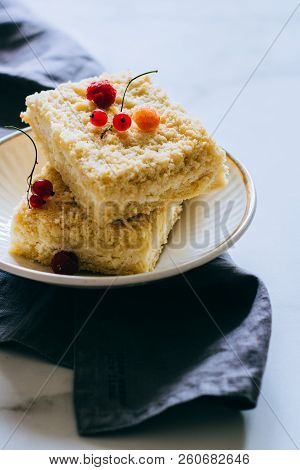Pieces Of Cottage Cheese Cake With A Crumble Decorated With Raspberries And Red Currants On A White