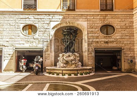 Rome/italy - August 27, 2018: Scooter Garage In The Facade In Front Of A Medieval Fountain
