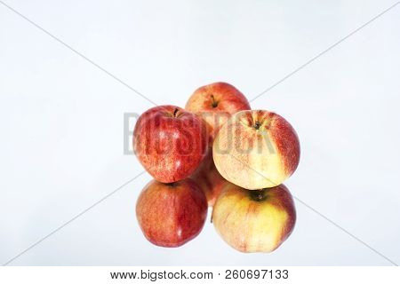 Three Apples On Table With Reflection. Autumn Abstract Photo