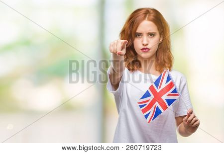 Young beautiful woman holding flag of united kingdom over isolated background pointing with finger to the camera and to you, hand sign, positive and confident gesture from the front