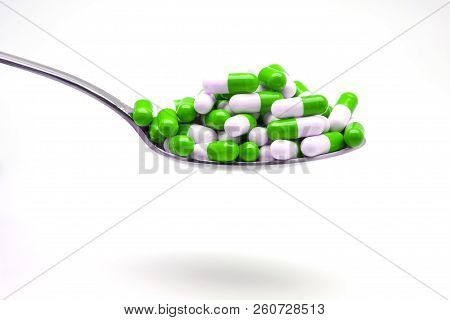 Spoon With Green Capsules On White Fund