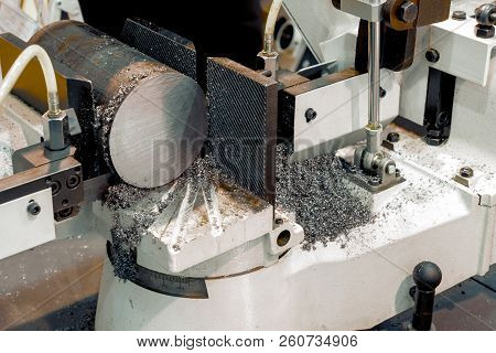 Automatic Bandsaw Sawing Metal Workpiece. From The Cooling Pipes Supplied Lubricity Emulsion.