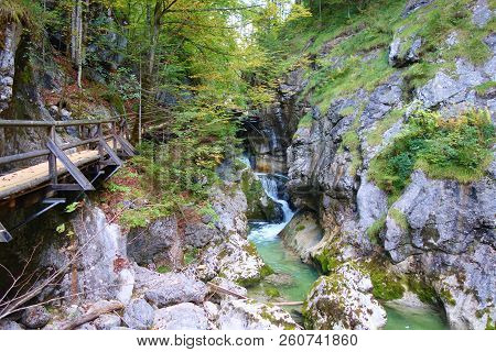 Wooden Footbridge Hiking Trail Along A Clear Mountain Stream Flowing Through A Spectacular Rocky Gor