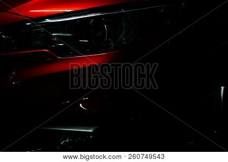 Closeup Headlight Of Shiny Red Luxury Suv Compact Car. Elegant Electric Car Technology And Business 