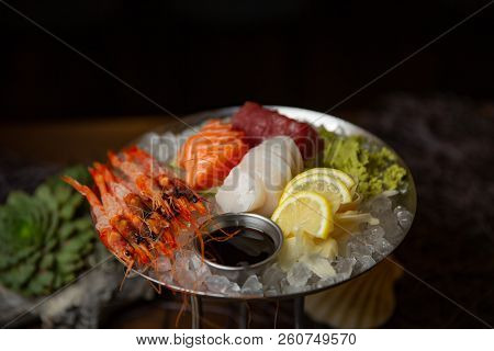 Mixed Sliced Fish Sashimi And Shrimps On Ice In Black Bowl. Sashimi Salmon Tuna Hamachi Prawn And Su