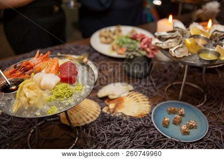 Mixed Sliced Fish Sashimi And Shrimps On Ice In Black Bowl. Sashimi Salmon Tuna Hamachi Prawn And Su