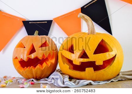 Few Orange Pumpkins Of Different Size Carved Into Jack O Lantern On Wooden Table. Background, Copy S