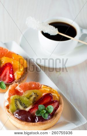 Fresh Fruit And Berry Tart Dessert With Toss Sugar On Wooden Background. Delicious Sweet Cake With R