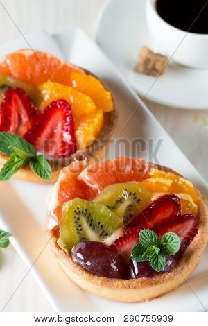 Fresh Fruit And Berry Tart Dessert With Toss Sugar On Wooden Background. Delicious Sweet Cake With R