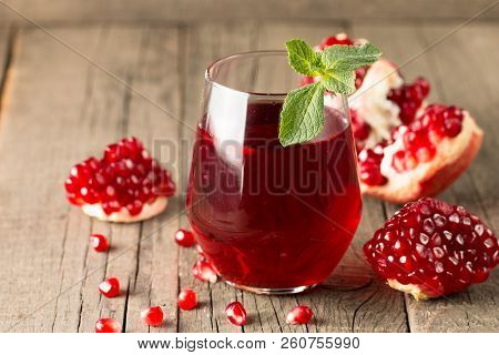 A Glass Of Pomegranate Juice With Fresh Pomegranate Fruits On Wooden Table. Vitamins And Minerals. H