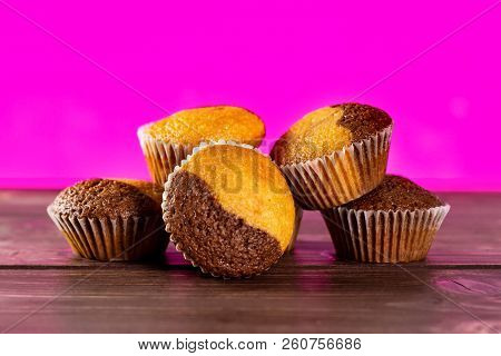 Group Of Five Whole Fresh Baked Marble Muffin With Pink In Background