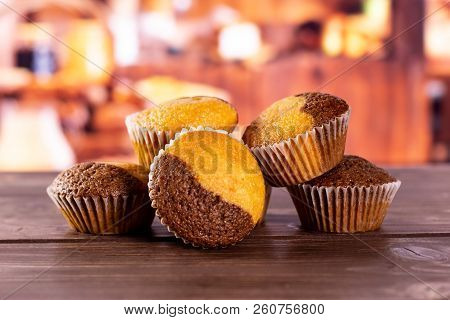 Group Of Five Whole Fresh Baked Marble Muffin With Rustic Wood Kitchen In Background