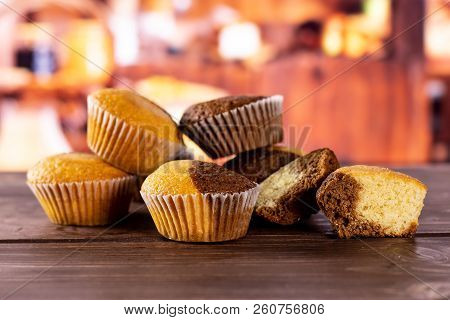 Group Of Five Whole Two Halves Of Fresh Baked Marble Muffin With Rustic Wood Kitchen In Background