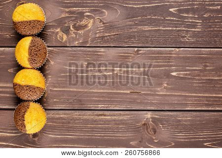 Group Of Four Whole Fresh Baked Marble Muffin Flatlay On Brown Wood