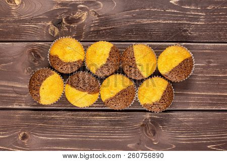 Group Of Eight Whole Fresh Baked Marble Muffin Flatlay On Brown Wood
