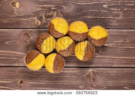 Group Of Eight Whole Fresh Baked Marble Muffin Flatlay On Brown Wood